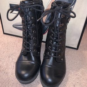 Black heeled combat boots with a chain